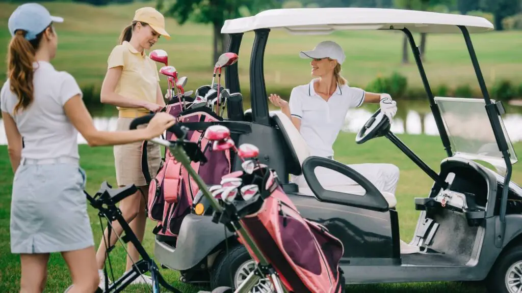 Female Golfers sitting on golf cart on golf course