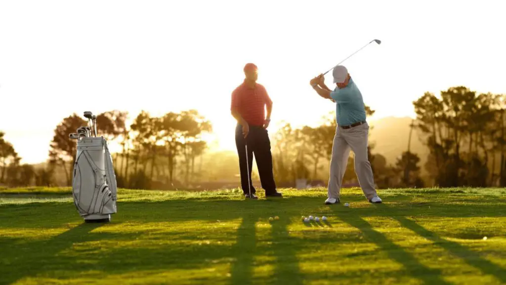 Two golfers teeing up shots on golf course