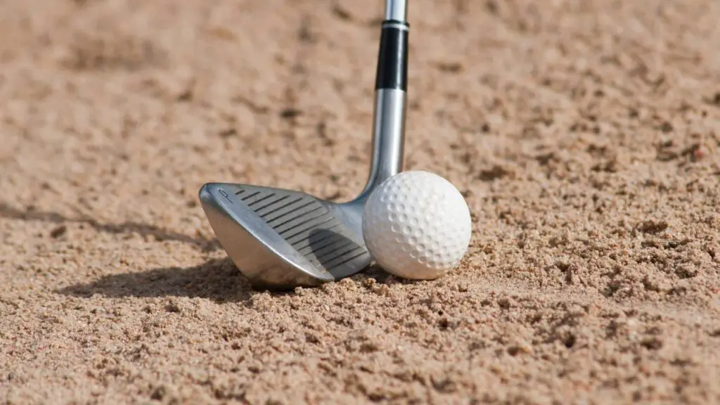 Wedge hitting golf ball out of bunker
