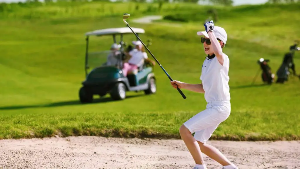 Young golfer celebrating hitting shot