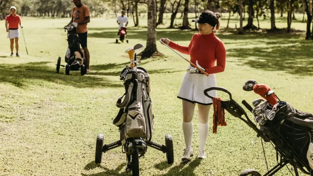 Female golfer selecting golf clubs from golf bag