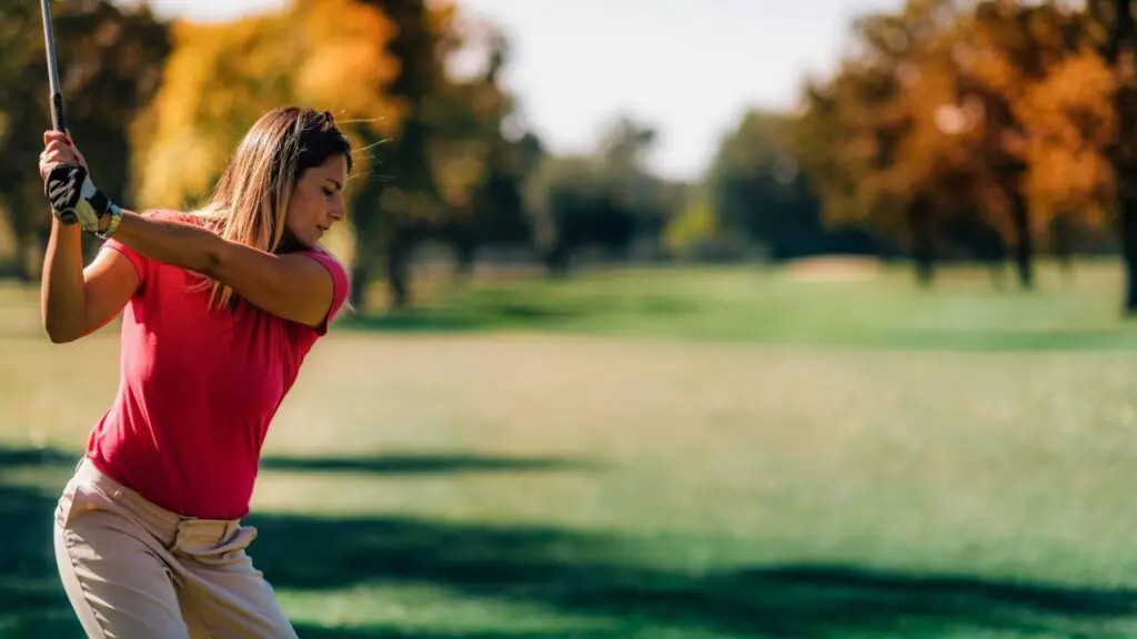 Golfer hitting tee shot on golf course