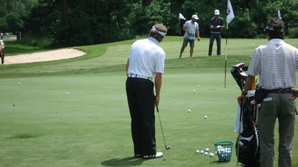Golfing assessing putt shot on green