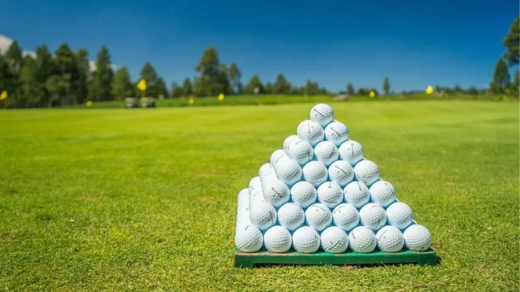 Golf balls stacked on golf course green