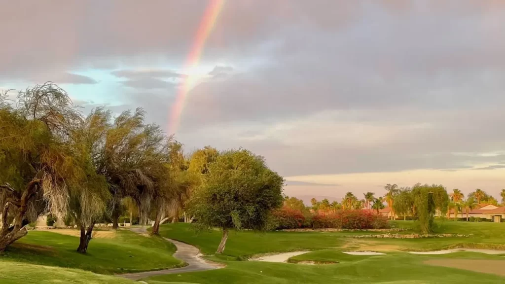 Golf course with rainbow in sky after rainfall