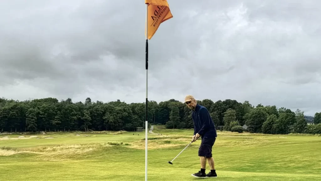 Golfer hitting putt on golf course