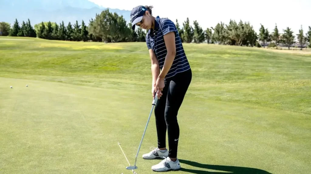 Female golfer putting shot on golf course