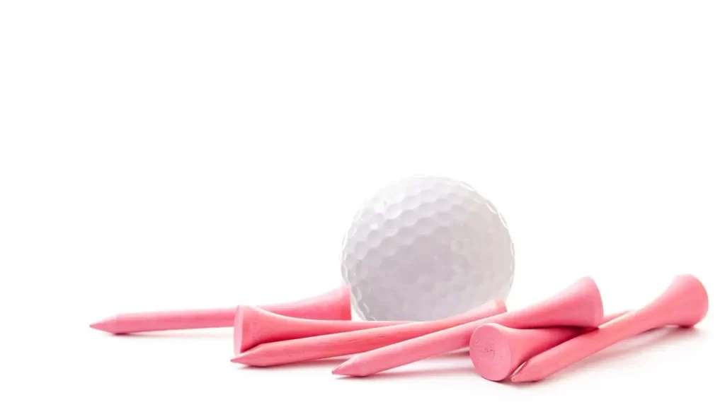 Golf ball and pink golf tees lying on white background