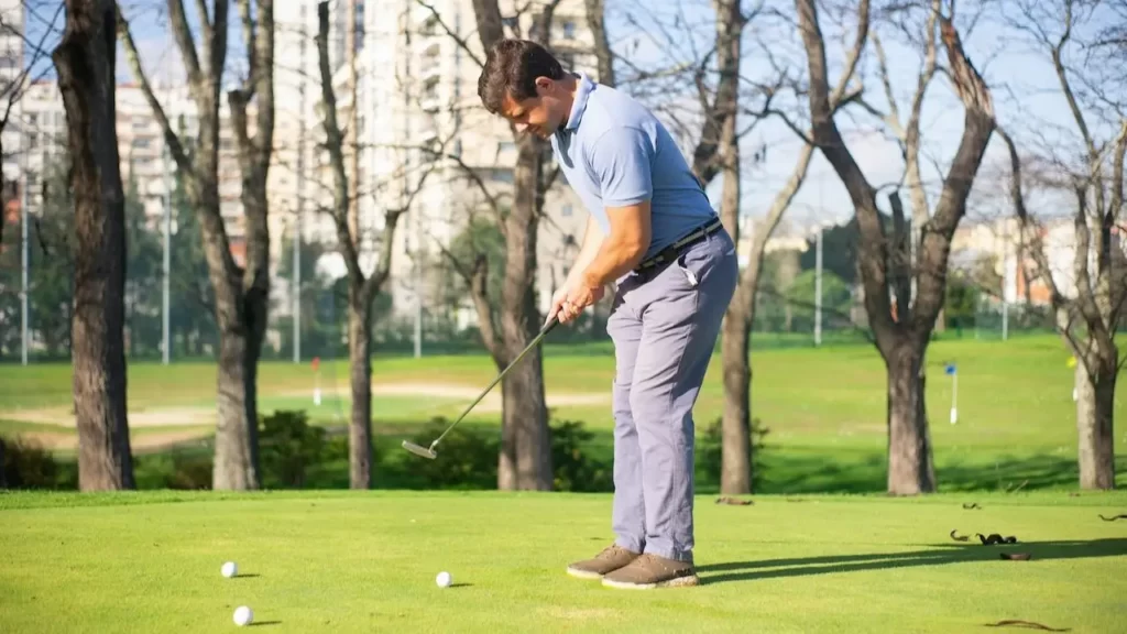 Golfer practicing putting on golf course