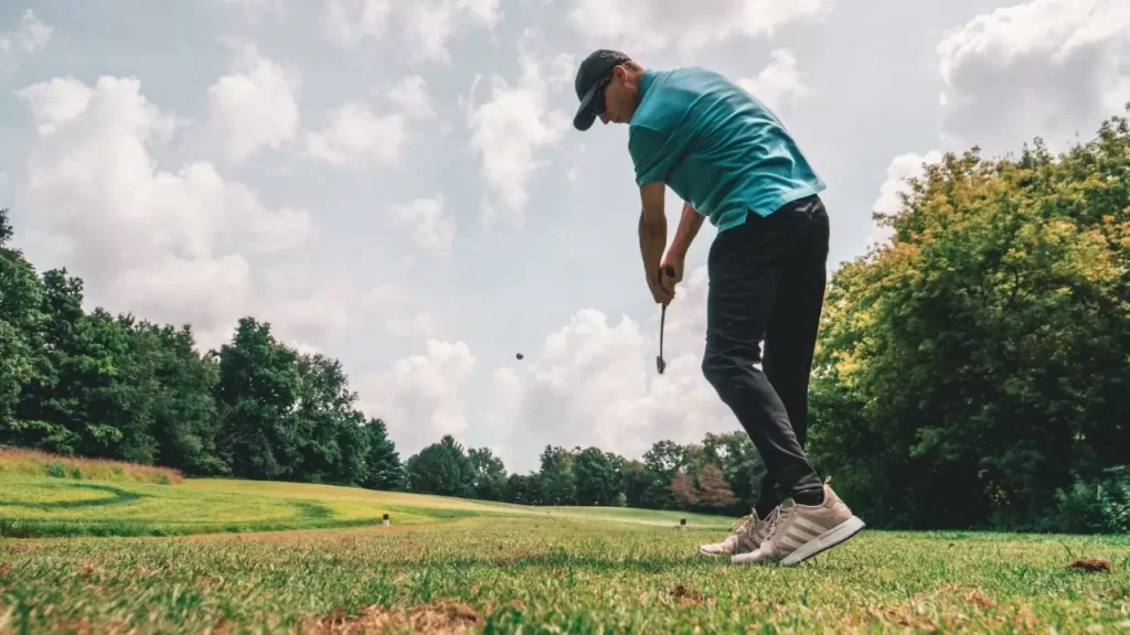 Golfer swinging golf shot on golf course