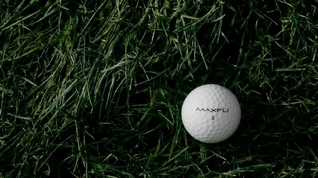 One golf ball sitting on golf course green grass