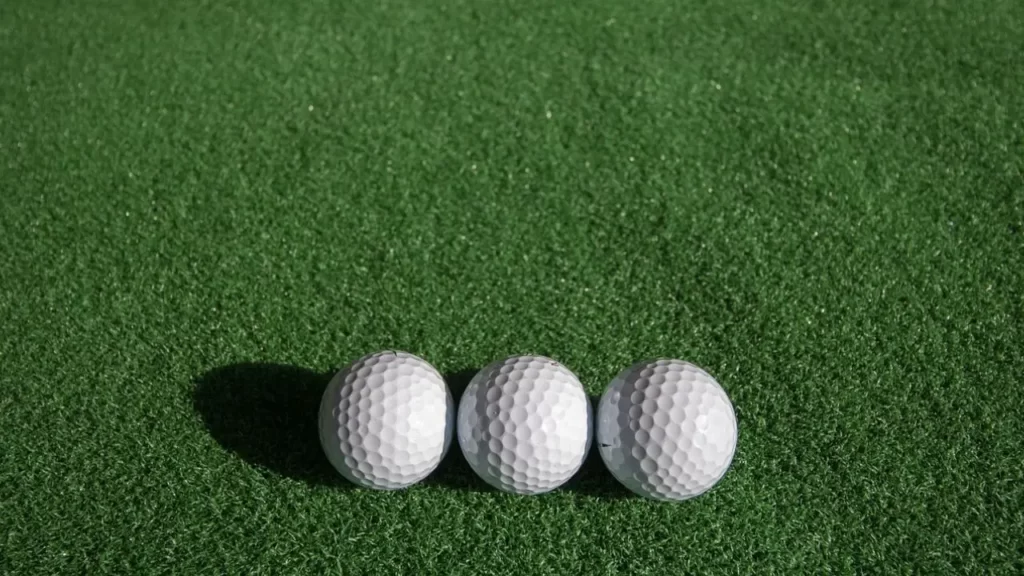 Three golf balls sitting next to each other