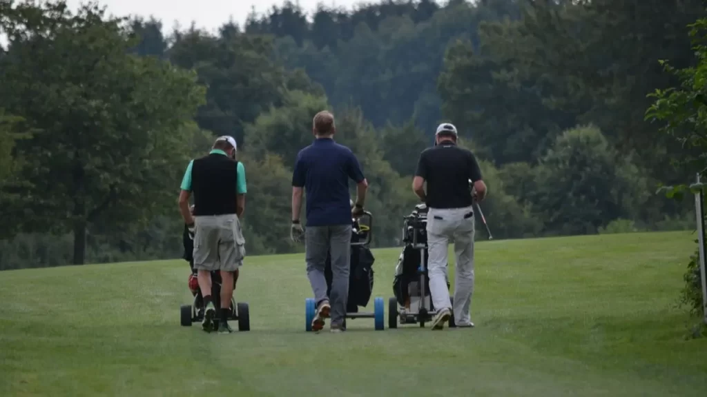 Three golfers walking on golf course