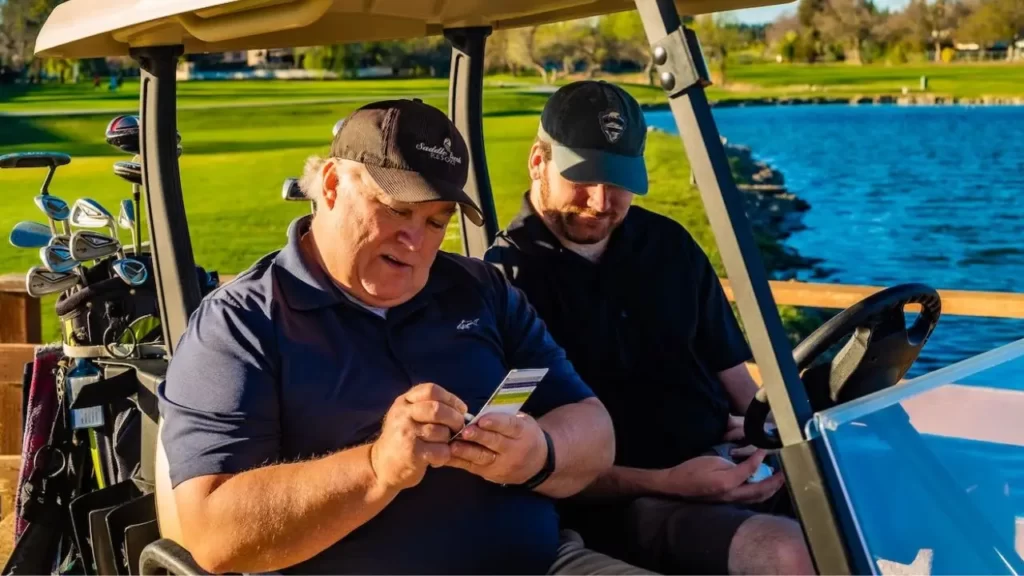 Two golfers keeping score on golf cart