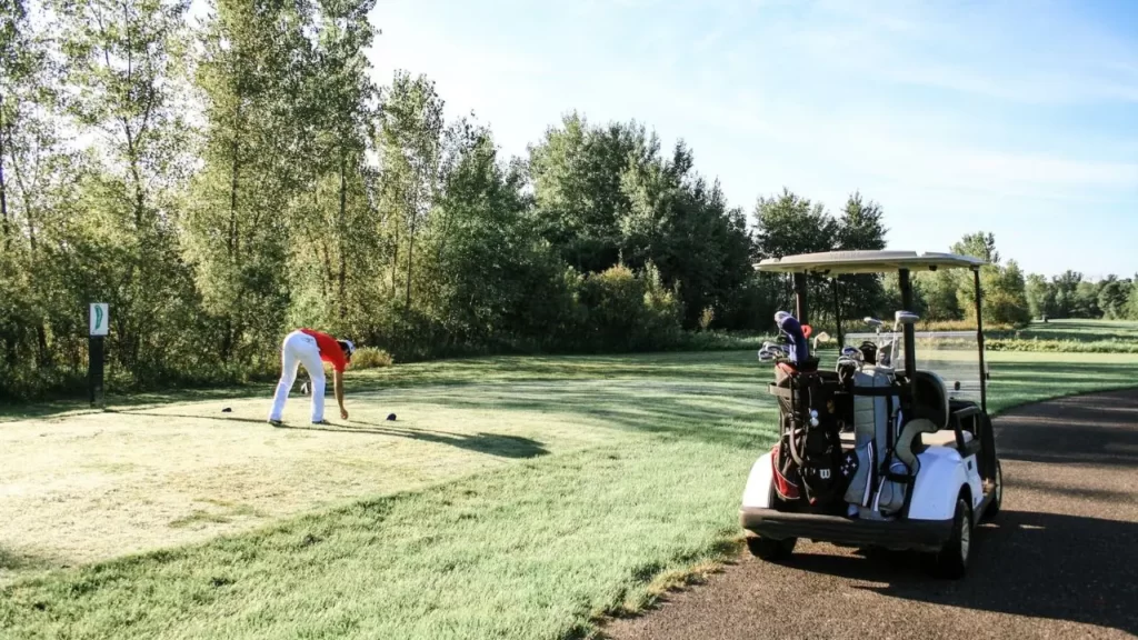 Golfer setting up ball for tee shot on golf course