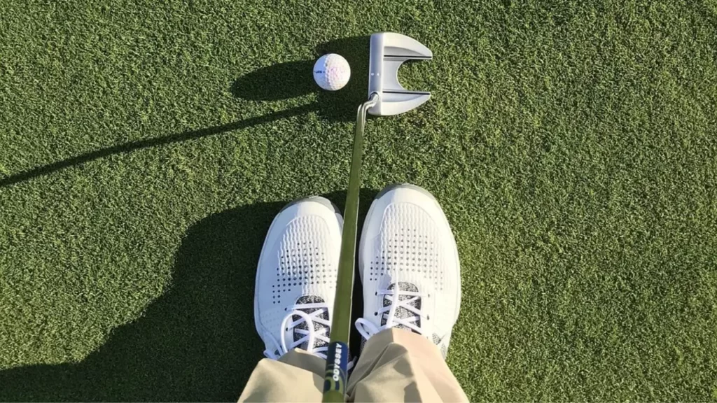 Shot from above of golf wedge and golf shoes