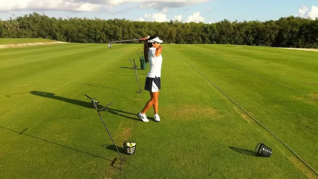 Women golfer practicing shots on driving range