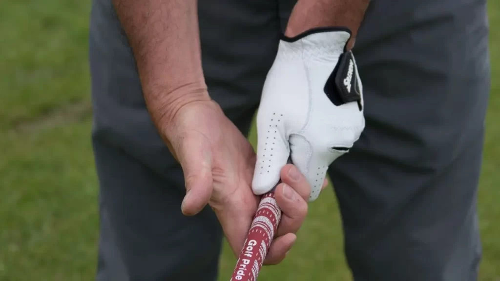 Golfer holding golf club with golf glove glove