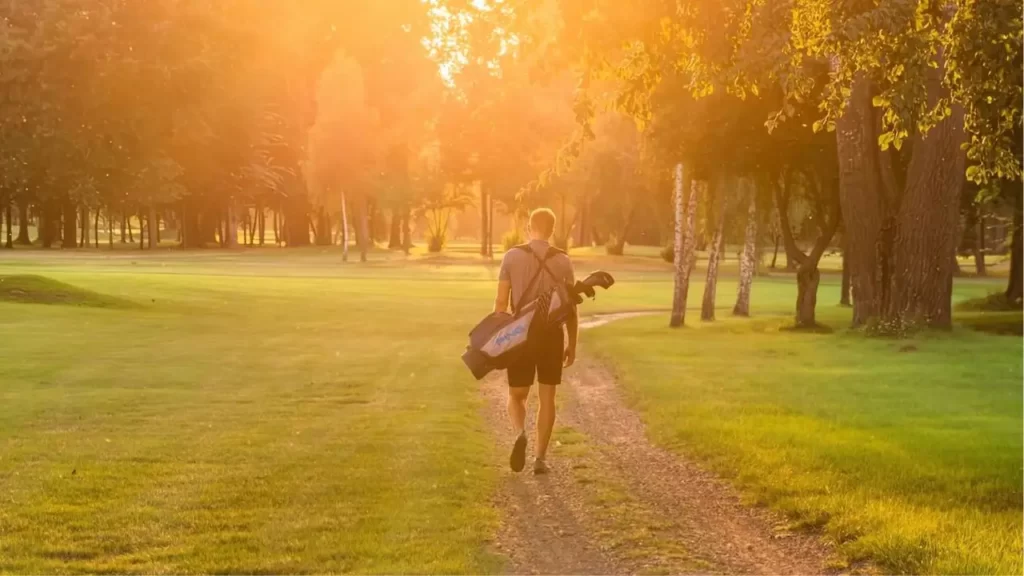 Golfer walking on golf course walkway path