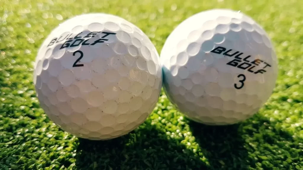 Two golf balls next to each other on course