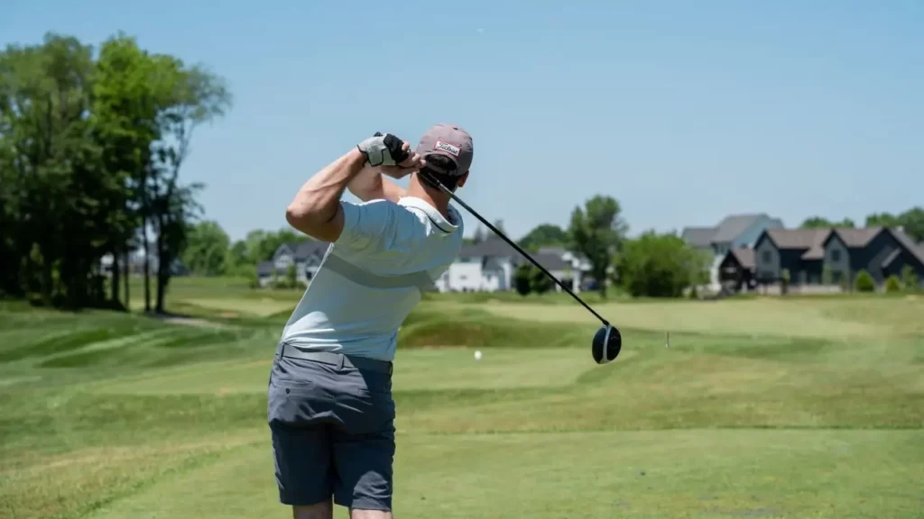 View of a golfer from behind hitting golf shot