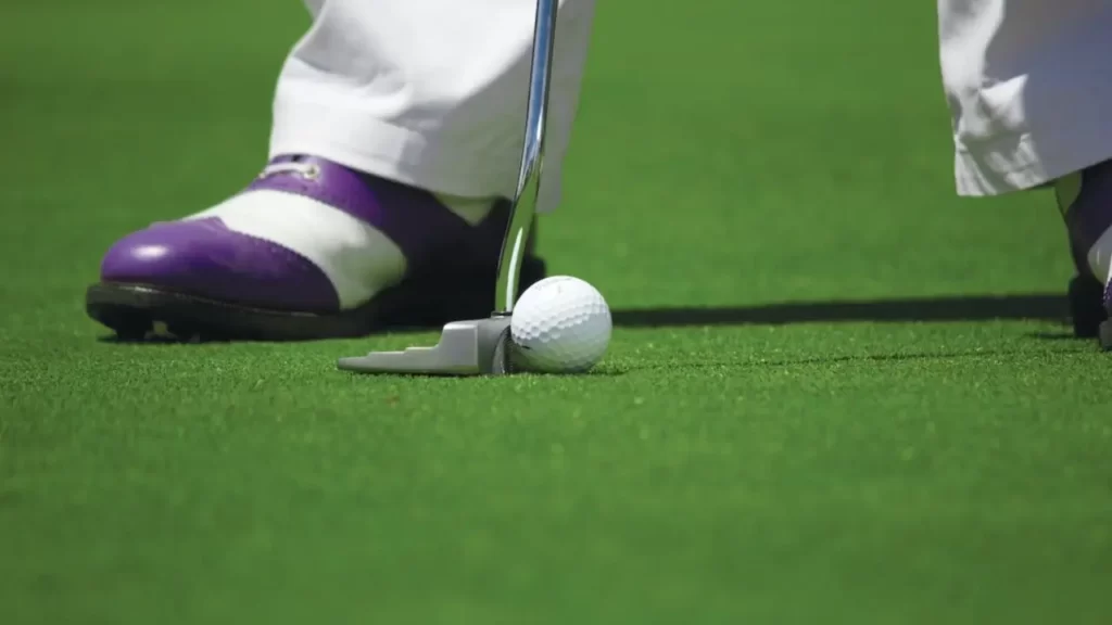 A golfer lining up a putt shot on a golf ball on a golf course green