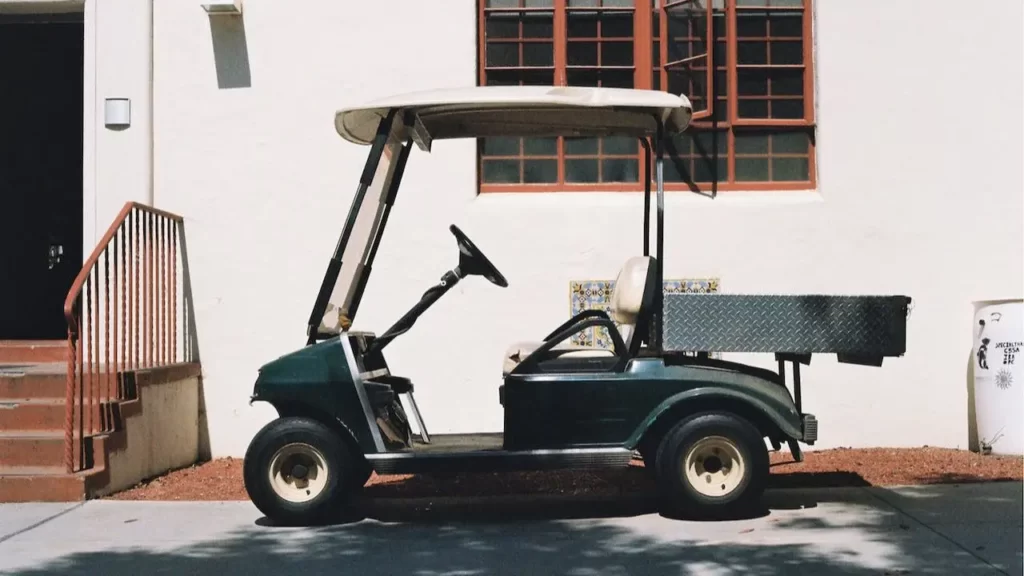 A golf cart parked in front of a wall