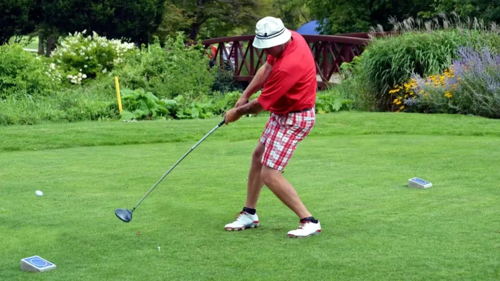 A golfer hitting a golf ball with a driver