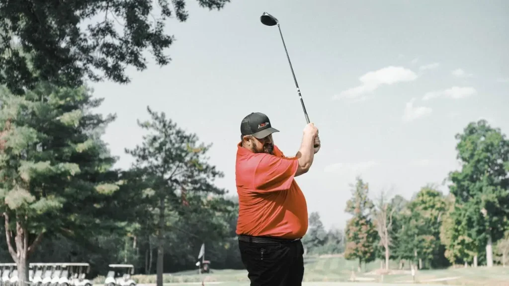 A golfer swinging a golfer club on a golf course