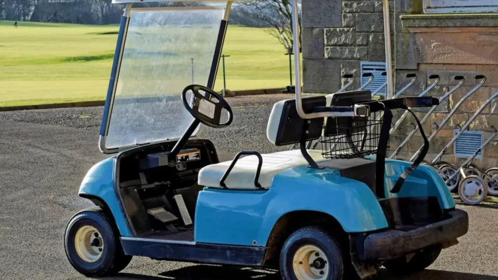 A blue golf cart parked at a golf course parking lot