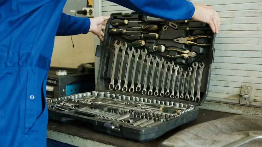 A mechanic using a tool set of spanners for a golf cart