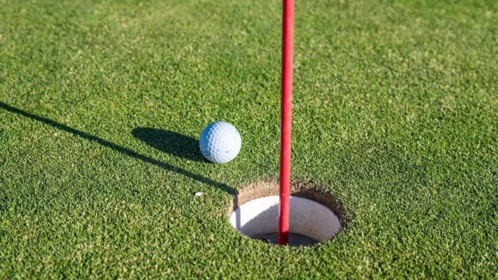A golf ball heading towards the hole on a golf course