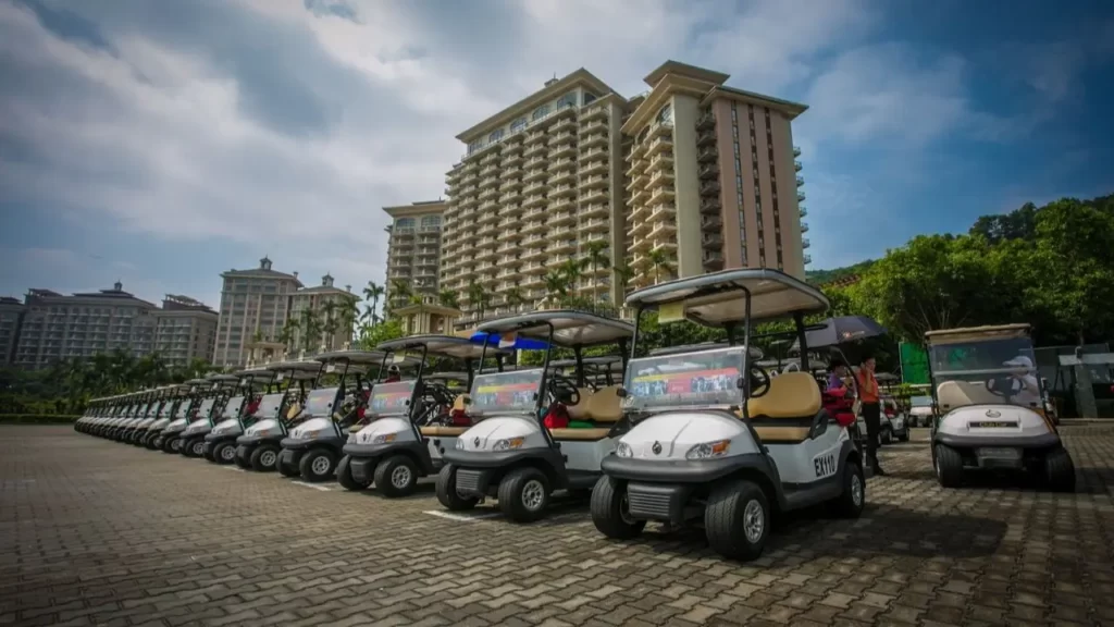 A line of golf carts parked in front of buildings