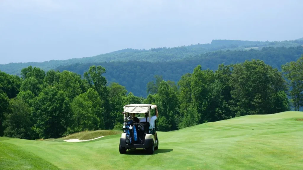 A golf cart parked on a golf course viewing a mountain