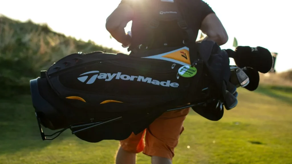 A golfer carrying a Taylor Made golfer bag