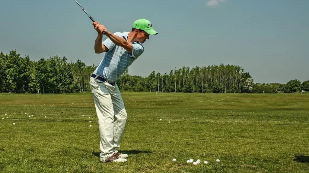 A golfer at a golf driving range hitting golf balls