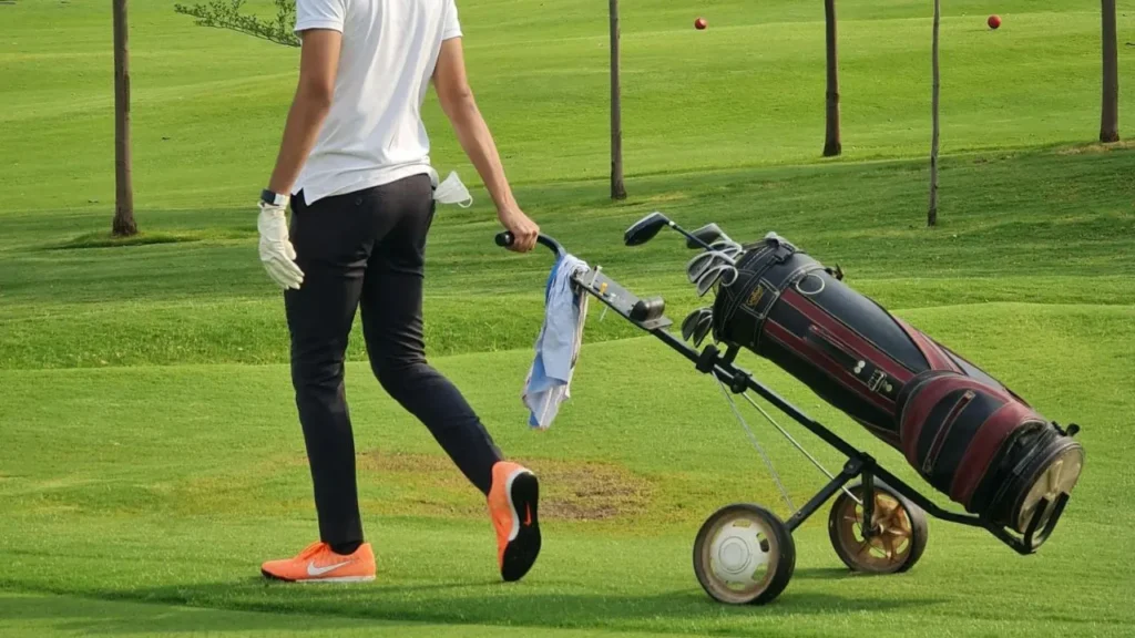 Golfer pulling a golf bag on a golf trolley on a course